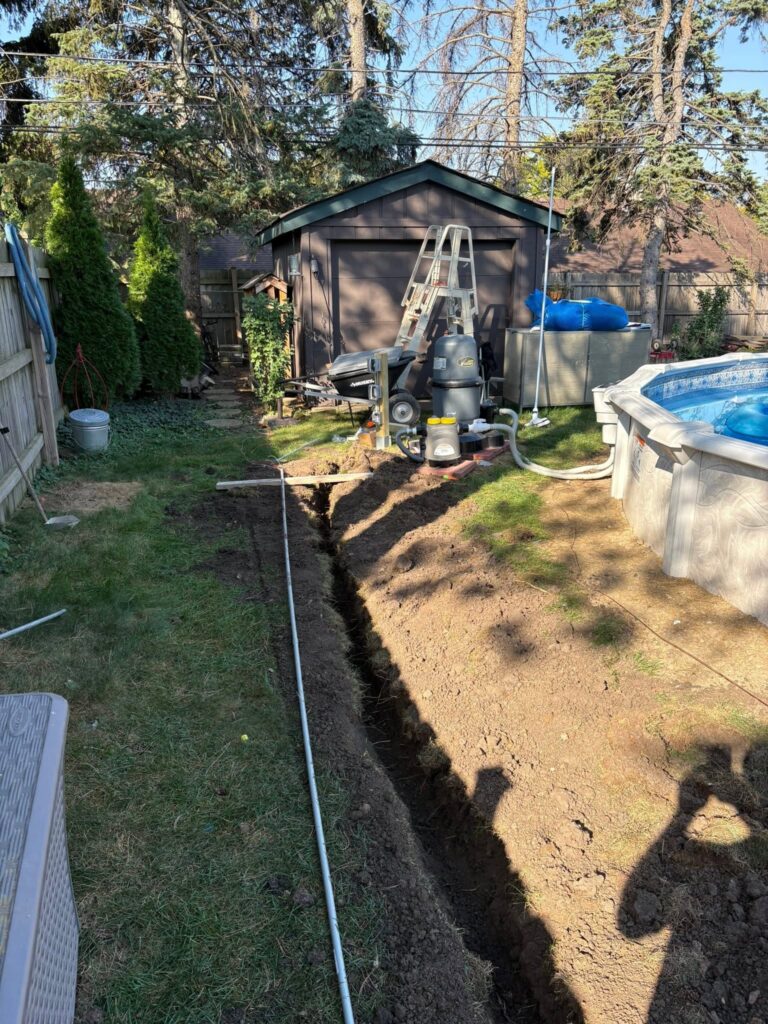 Electrical conduit trench being installed around an above-ground pool