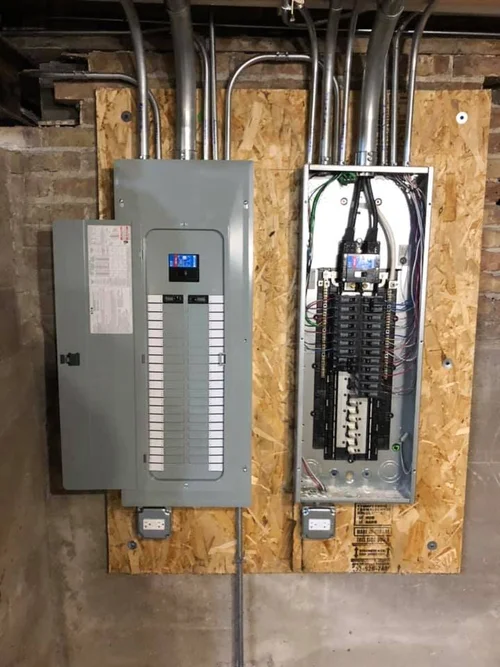 New residential electrical panels installed on an unfinished basement wall