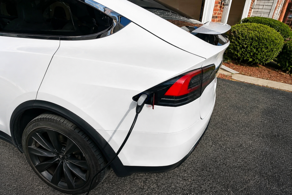 White electric vehicle connected to a home charging system